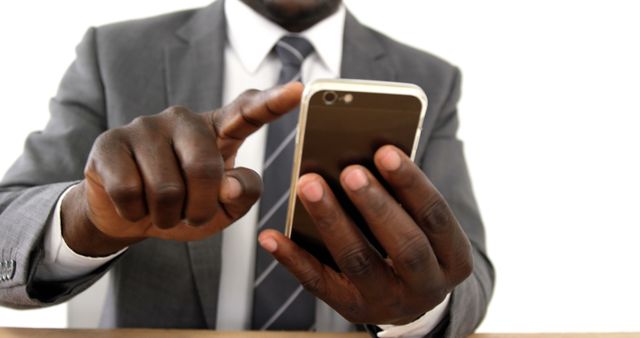 Businessman in a suit using smartphone focusing on the screen. Ideal for concepts related to technology in business, mobile communication, corporate environments, productivity, and professional work settings.