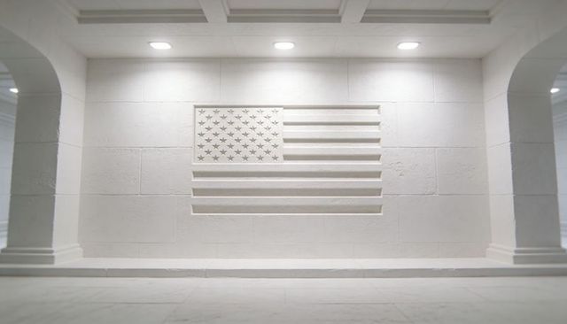 Minimalist carved american flag bas-relief on marble wall in symmetrical memorial hall