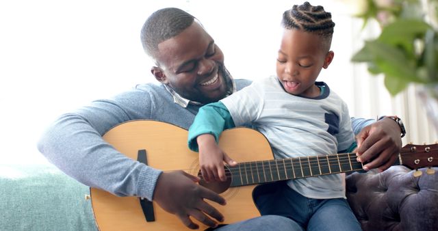 Happy Father and Son Learning to Play Guitar Together at Home - Download Free Stock Images Pikwizard.com