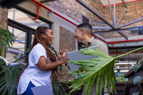 Excited Coworkers Exchanging Ideas in Modern Office Workspace