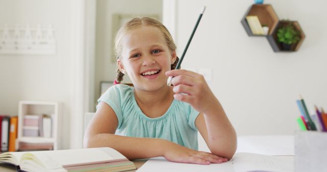 Portrait of caucasian girl holding a pencil smiling looking at the camera at home. distance learning and online education concept