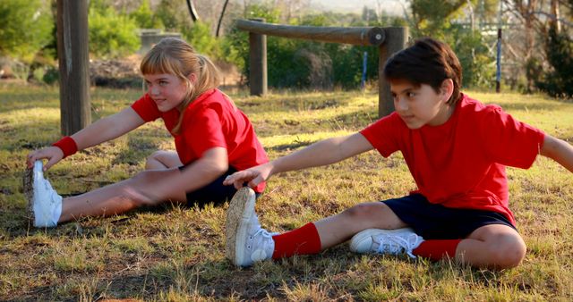 Children Stretching Outdoors Together in Red Sports Uniforms - Download Free Stock Images Pikwizard.com