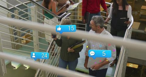 Corporate team descending stairs collaborating with devices and social media notifications