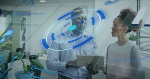 Two professionals collaborating with tablet and holographic HUD in modern office workspace