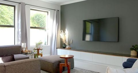 Minimalist living room with wall-mounted tv, neutral palette and modern console storage