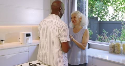 Senior Couple Enjoys Romantic Moment in Modern Kitchen
