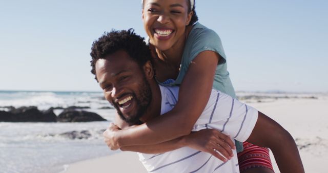 Happy couple enjoying playful piggyback ride on beach - Download Free Stock Images Pikwizard.com