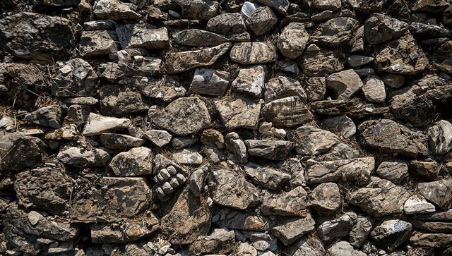 Weathered dry stone wall revealing layered fieldstone texture and rustic rockwork details