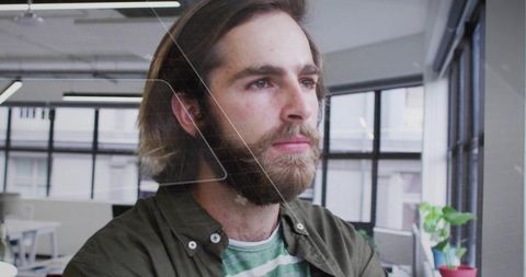 Bearded Man Focused on Technology in Modern Open-Office Space
