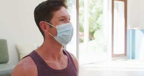 Man in Face Mask Practicing Indoor Yoga for Wellness