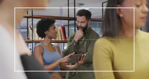 Diverse Team Discussing Project on Tablet in Modern Office