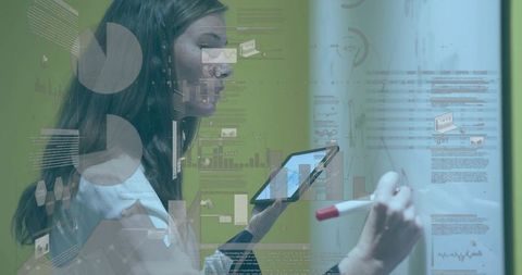 Businesswoman writing on glass board holding tablet with data visualizations and charts