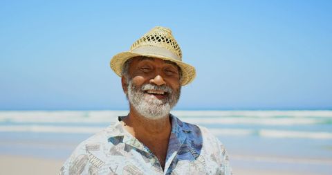 Senior Man Smiling on Sunny Beach Wearing Straw Hat