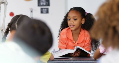 Curly-Haired Schoolgirl Presenting Book Report in Classroom - Download Free Stock Images Pikwizard.com