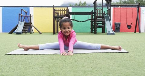 Young Girl Practicing Splits in Colorful Playground with Joyous Spirit