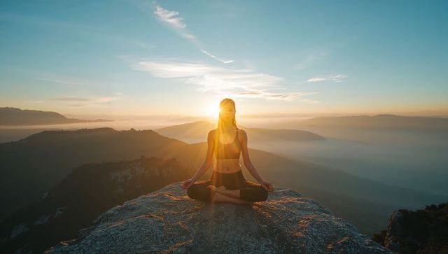 Serene Meditating Woman on Mountain Summit at Sunrise