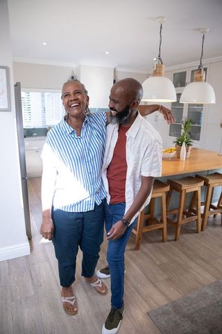 Senior Mother and Adult Son Sharing Joyful Moment in Modern Kitchen