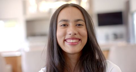 Smiling Young Girl with Long Brown Hair at Home