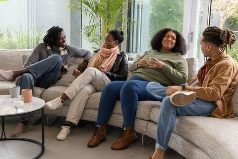 Friends chatting on gray sectional sofa in modern living room