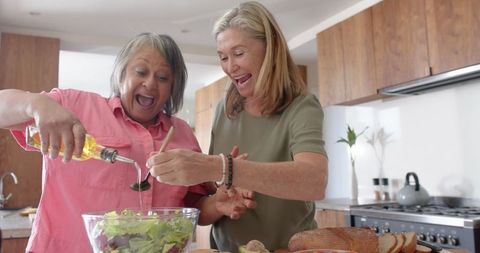 Senior Friends Joyfully Cooking in Modern Kitchen