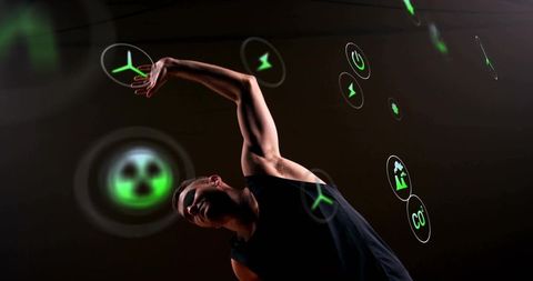 Contemporary dancer reaching through holographic green energy icons, dramatic stage motion