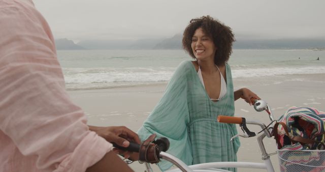 Smiling Woman Enjoying Beach with Bicycle on Overcast Day - Download Free Stock Images Pikwizard.com