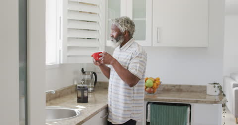 Elderly Man Enjoying Coffee at Home in Brightly Lit Kitchen