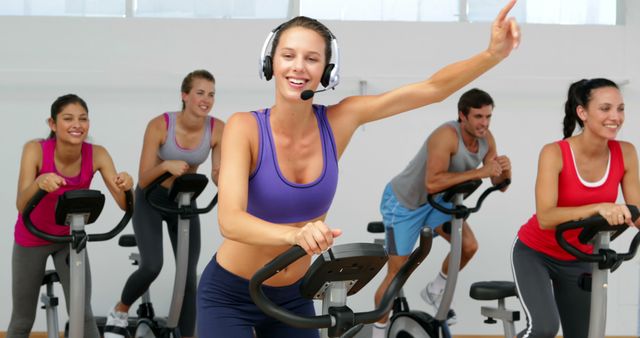 Happy Fitness Instructor Giving Spin Class with Engaged Participants - Download Free Stock Images Pikwizard.com