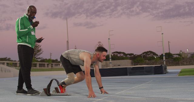 Diverse male coach and disabled athlete with running blade training at sunset - Download Free Stock Photos Pikwizard.com