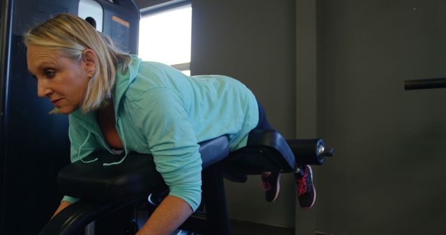 Senior woman using gym equipment for back extension exercise - Download Free Stock Images Pikwizard.com