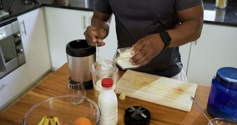Preparing healthy yogurt smoothie in modern kitchen at home