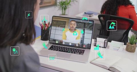 Remote sustainability meeting on laptop with eco icons overlay in modern coworking office