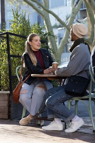 Friends Chatting Over Coffee at Outdoor Urban Cafe on Sunny Day Casual City Conversation