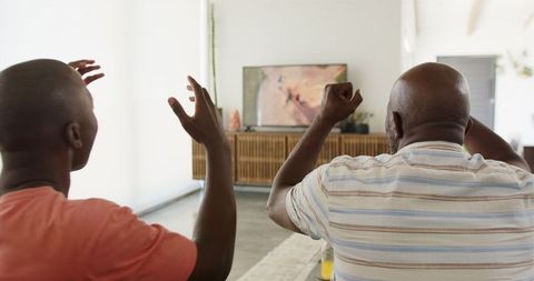 Father and Son Enjoying TV Together in Living Room