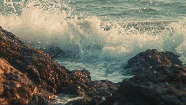 Dramatic ocean wave crashing against rocky shore with sea foam
