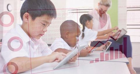 Asian boy tapping tablet in classroom with teacher and students using touchscreen tech