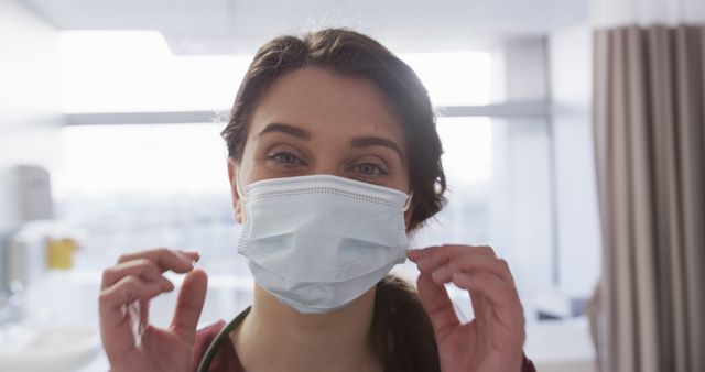 Smiling Female Doctor Adjusting Face Mask in Hospital - Download Free Stock Images Pikwizard.com