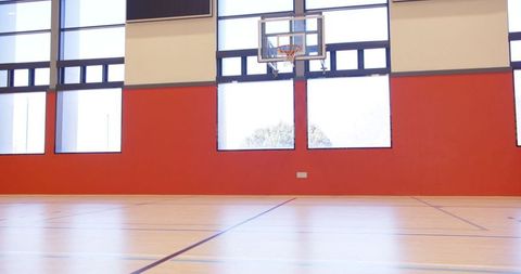 Spacious indoor basketball court with red accent wall