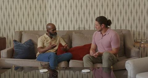 Two men having thoughtful conversation in living room