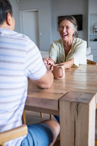 Smiling senior couple enjoying casual conversation at home