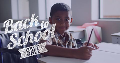 Back to School Sale with Smiling Schoolboy at Desk