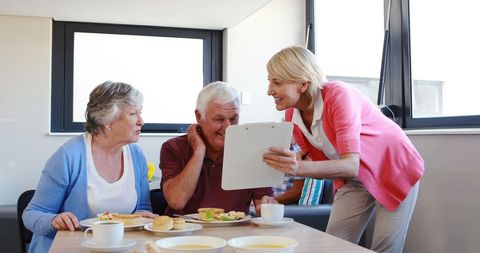 Dietitian Assisting Senior Couple with Meal Planning