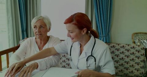 Healthcare worker assisting elderly patient with documents