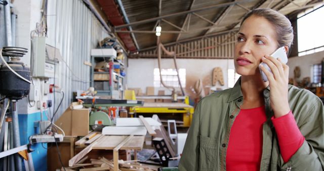 Female woodworker talking on phone in workshop - Download Free Stock Images Pikwizard.com