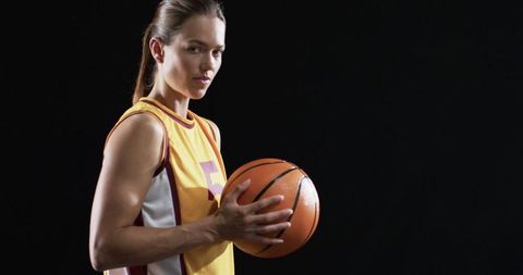 Confident Female Basketball Player Posing with Ball