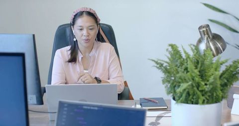 Female Professional Leading Virtual Meeting from Office Desk