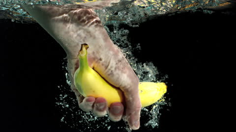 Hand Grabbing Banana Underwater in Slow Motion Splash