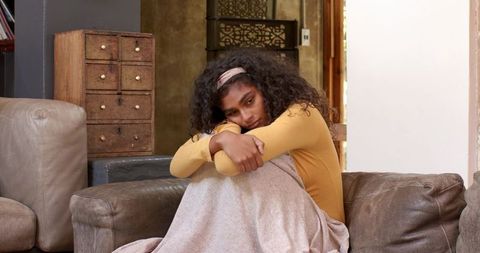 Woman in Introspective Mood Sitting on Living Room Couch