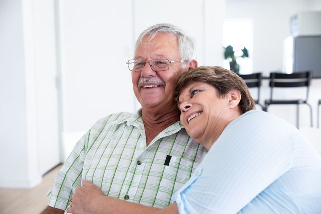 Senior couple enjoying a moment of affection and happiness at home. Ideal for use in advertisements, articles, and websites related to senior living, retirement, family bonding, and healthy relationships.
