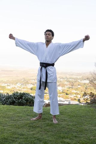 Martial Artist Practicing Meditation on Hilltop Outdoors